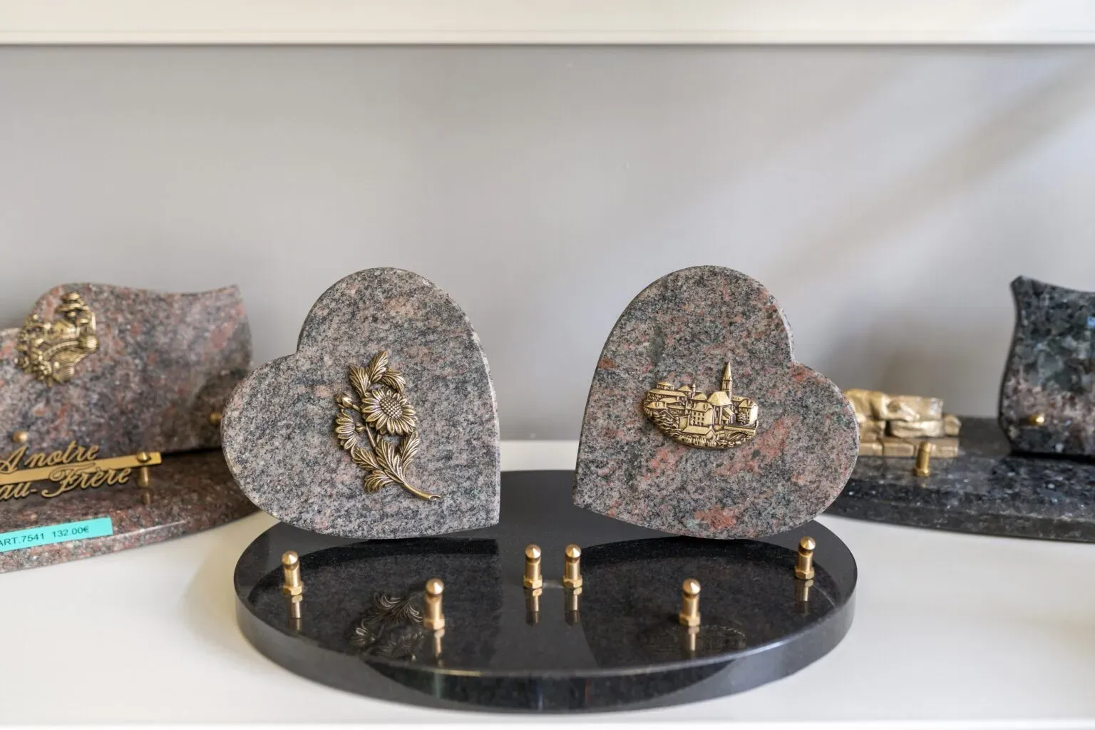 Plaques funéraires en granit en forme de cœur avec motifs sculptés.